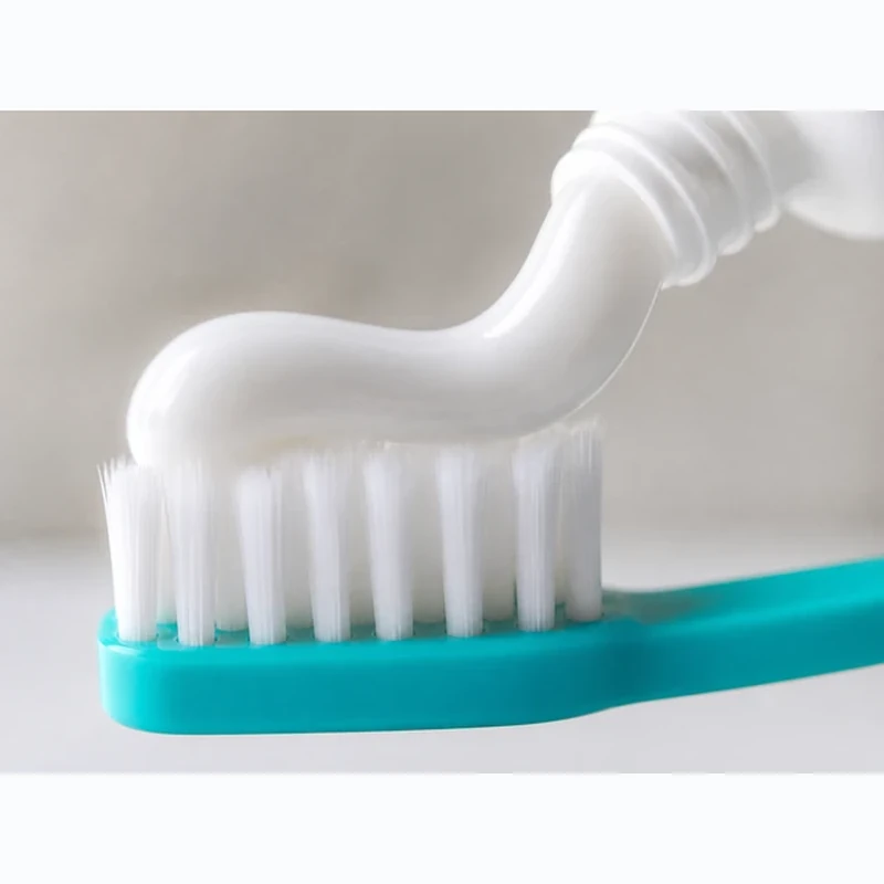 Mouthology toothpaste squeezed onto a teal toothbrush